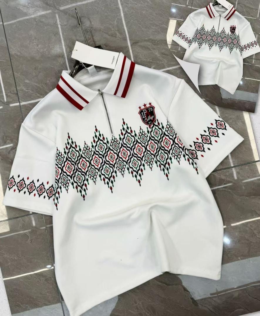 White polo shirt with geometric embroidery, striped collar and half-zip neck.