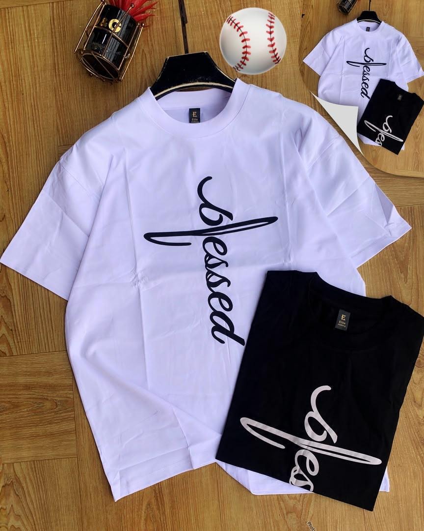 White and black Blessed script t-shirts laid out with baseball.