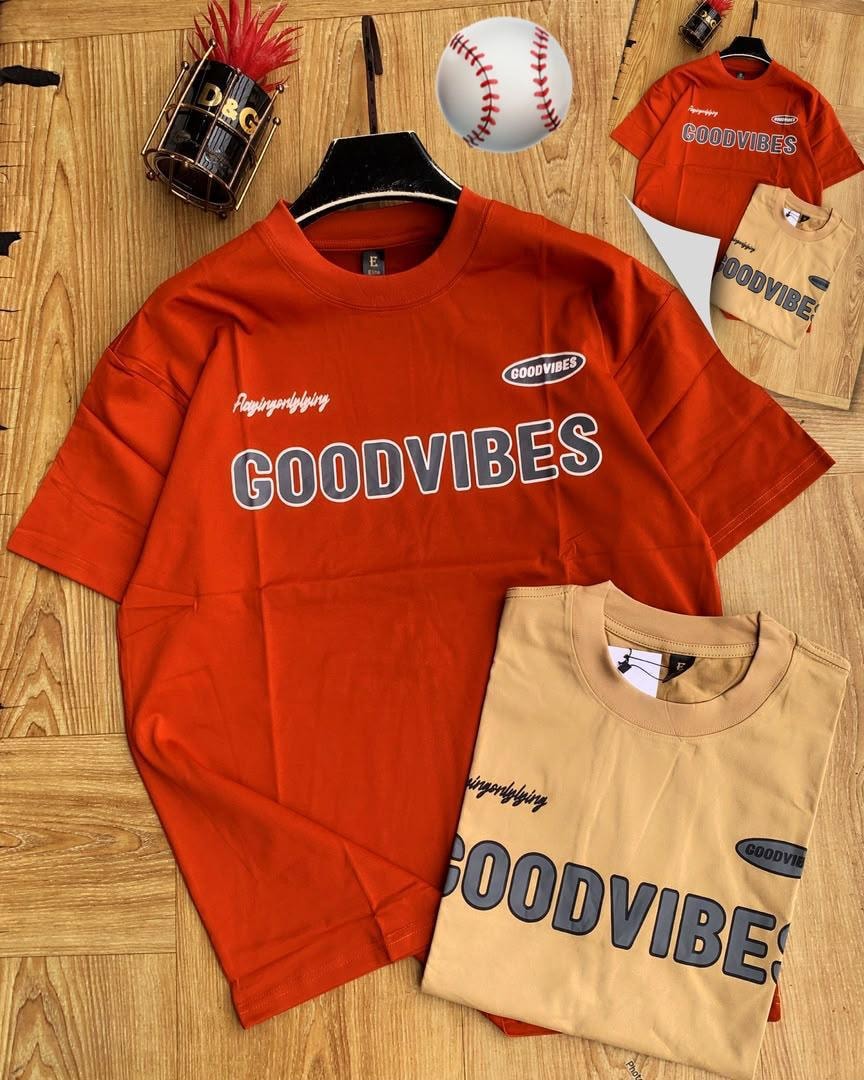 Red and beige Good Vibes printed t-shirts laid flat with accessories.