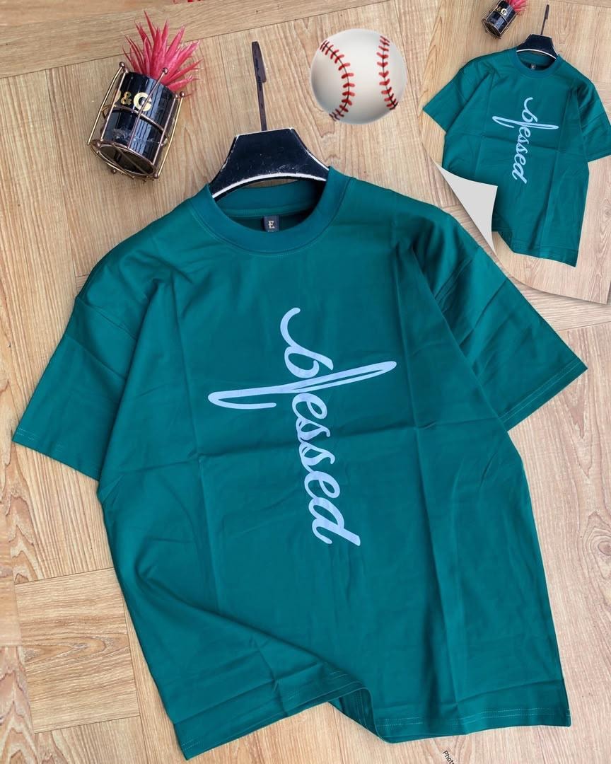 Green Blessed script t-shirt on wooden floor with props.
