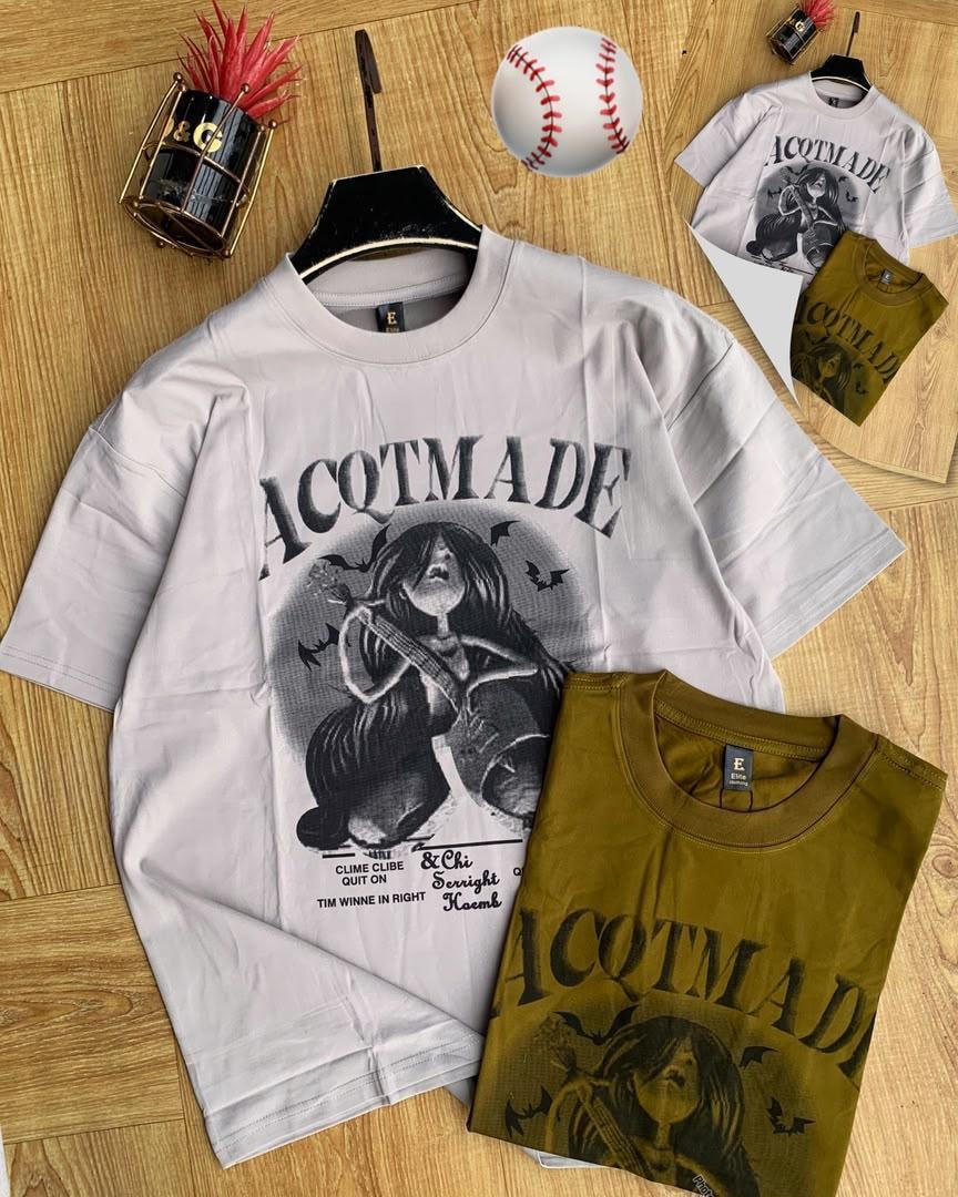 White and olive ACQTMade graphic t-shirts displayed with baseball and props.