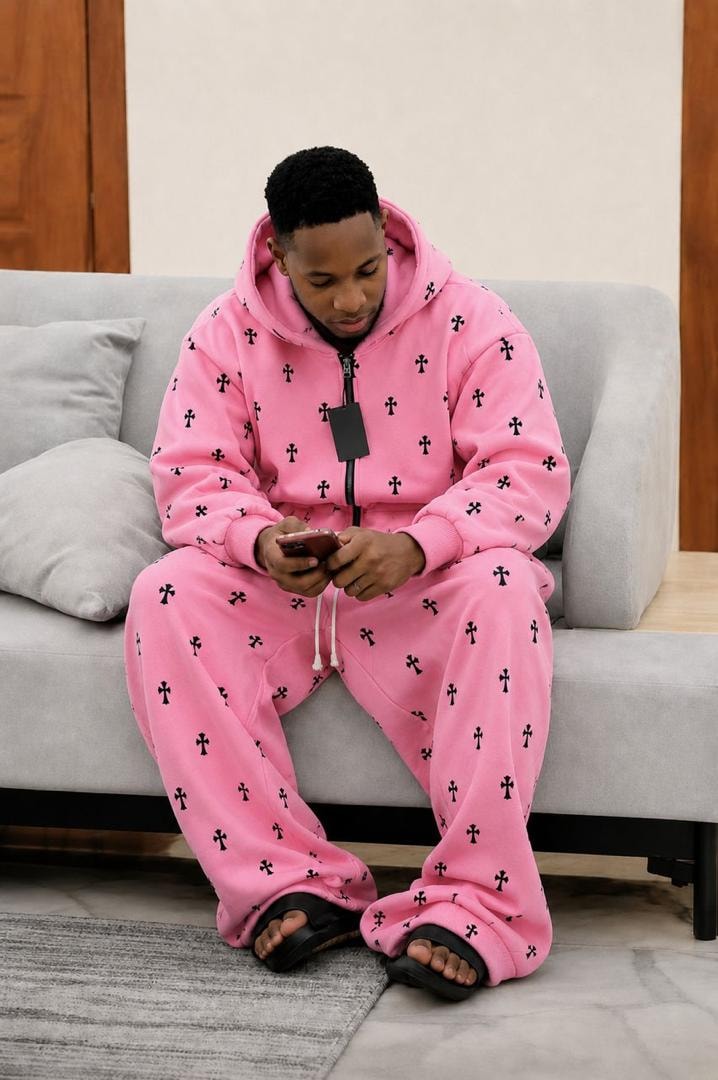 Model wearing pink cross print zip-up two-piece hoodie and pants set.