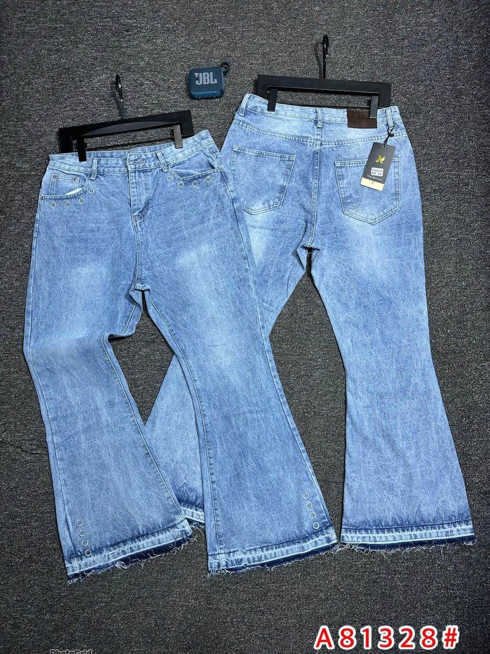 Light blue baggy jeans with eyelet hardware on hem and pockets, front and back views.