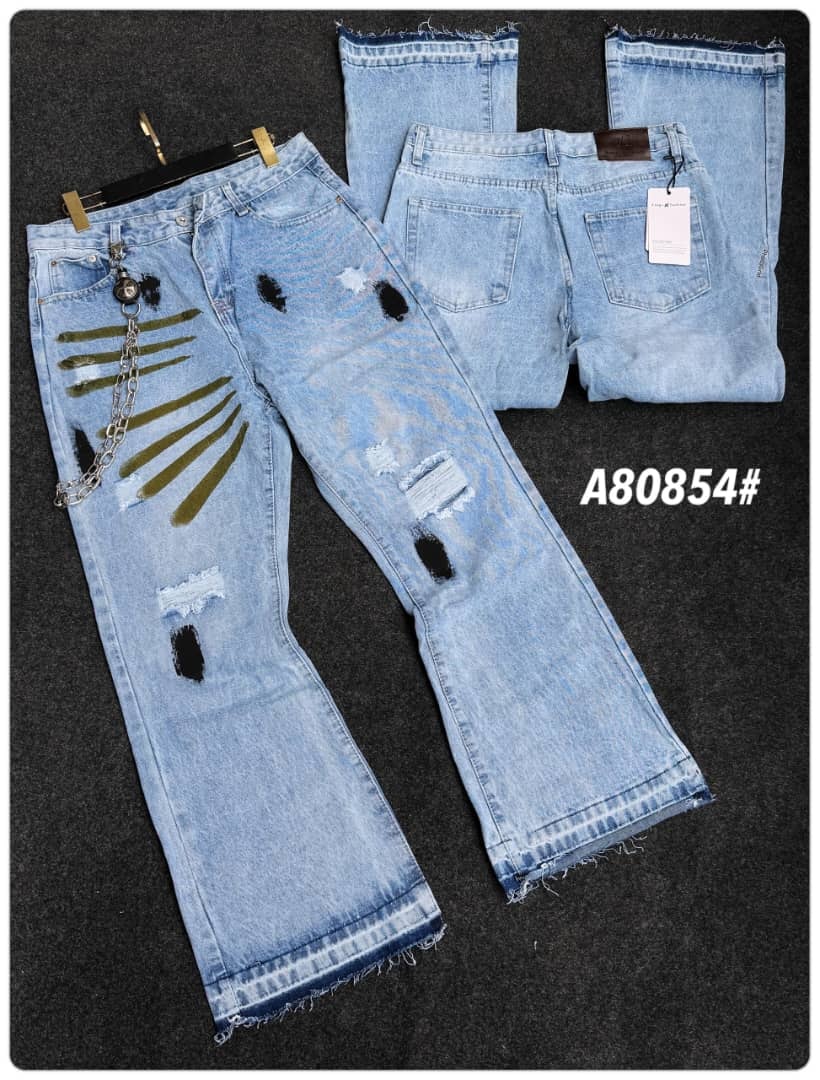 Light blue baggy flared jeans with green stripes, rips, chain accessory and back view.
