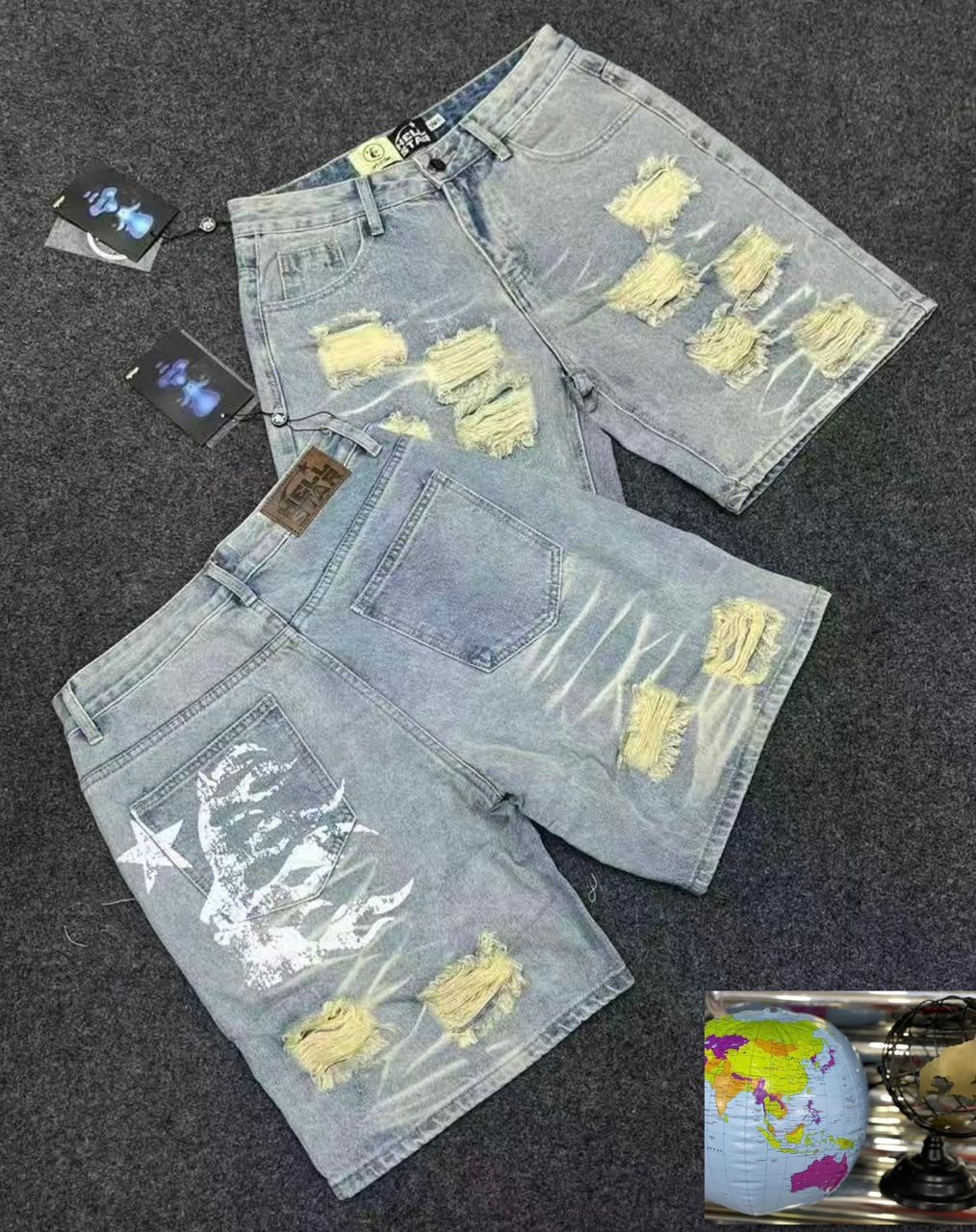 Light blue ripped baggy denim shorts with distressing and white graphic on back pocket.