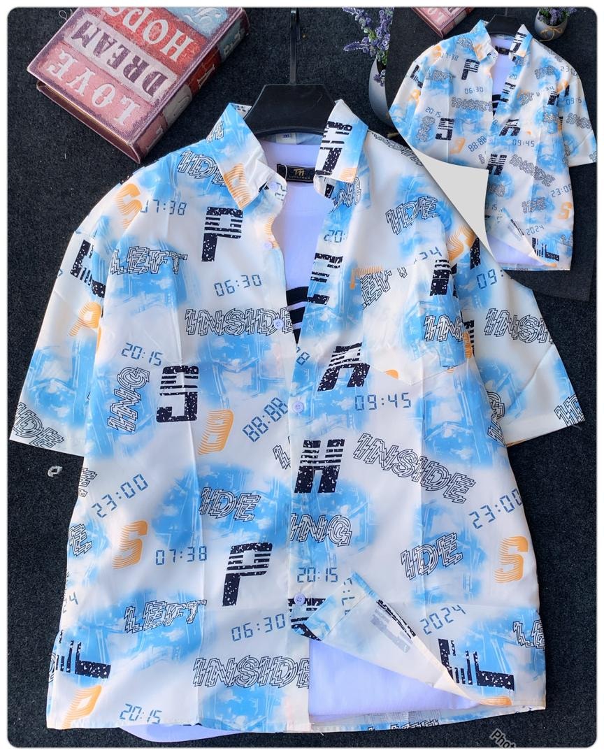 White short sleeve shirt with blue orange digital clock and city print on dark background.