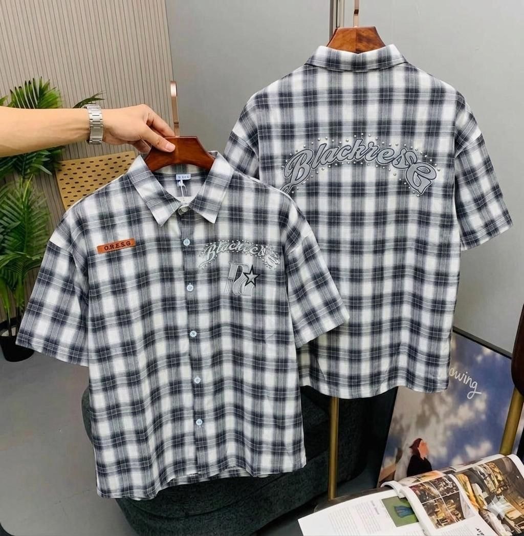 Black and white plaid short sleeve shirt on hanger displaying chest logo and back with detailed embroidery.