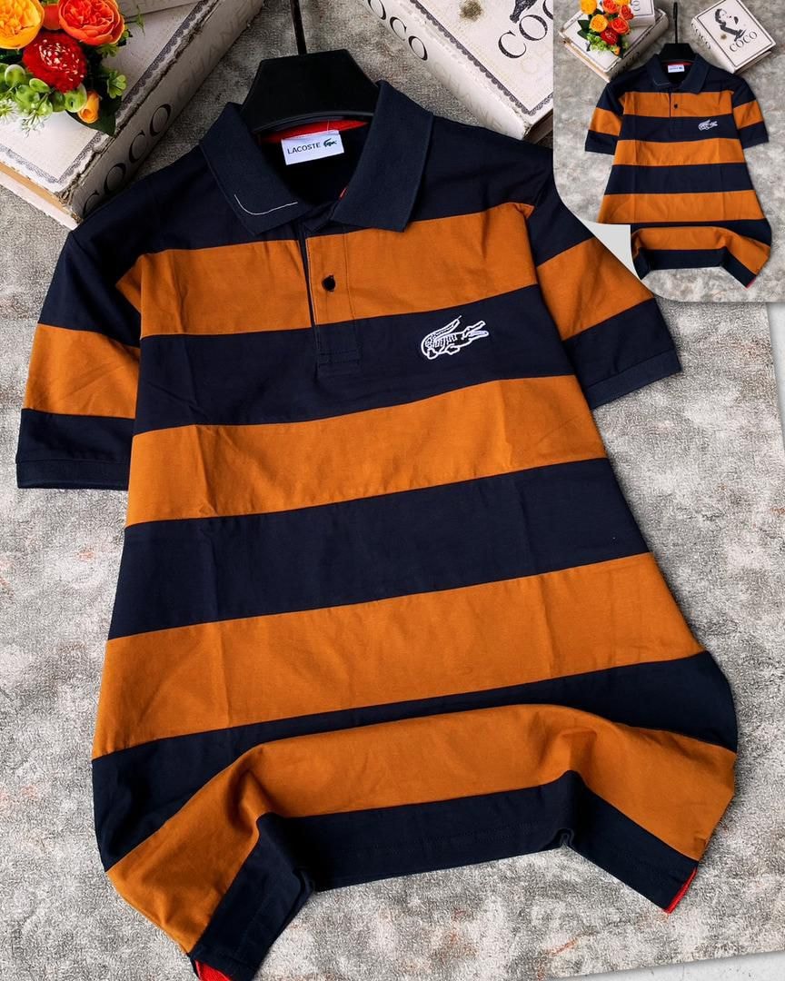 Lacoste striped polo shirt in navy and orange laid flat on textured surface.