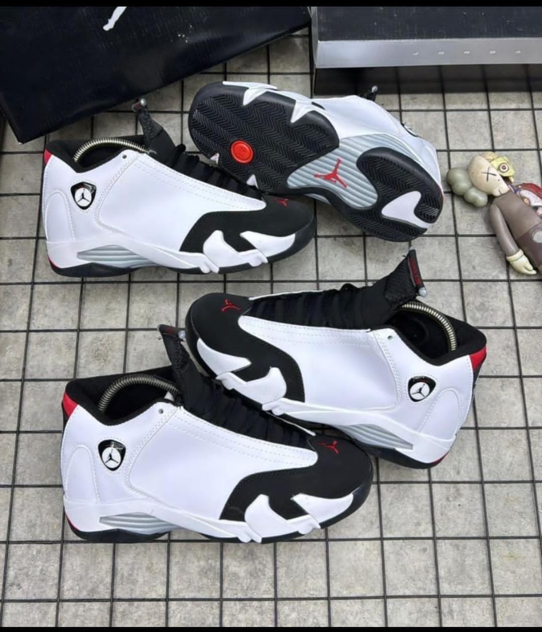 Air Jordan 6 sneakers in white black and red shown from multiple angles on tiled floor with accessories.