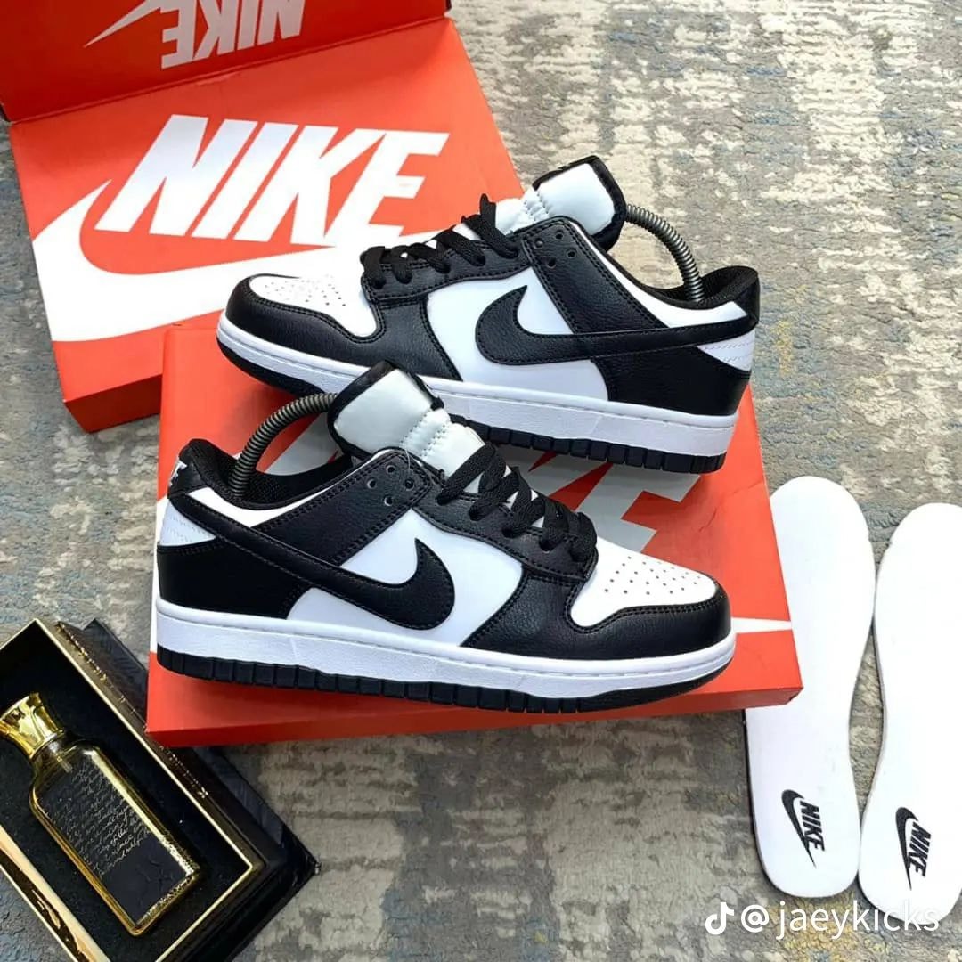 Nike Dunk Low Panda in black and white displayed on orange Nike box with insoles.