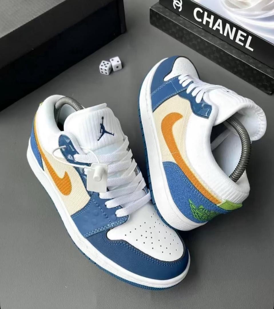 Multi-color blue white orange green Air Jordan 1 sneakers on gray surface.