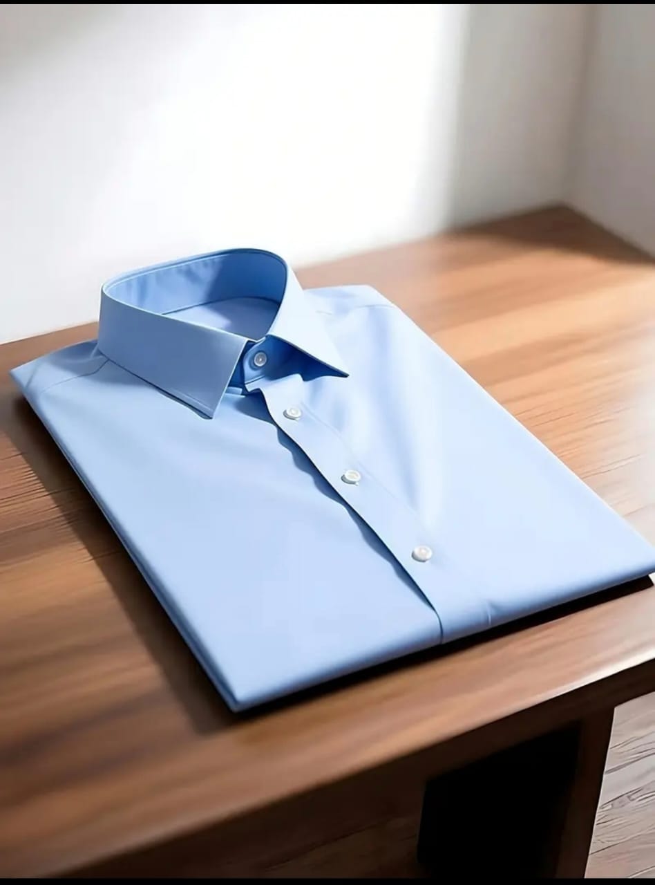 Light blue long sleeve dress shirt on wooden table.