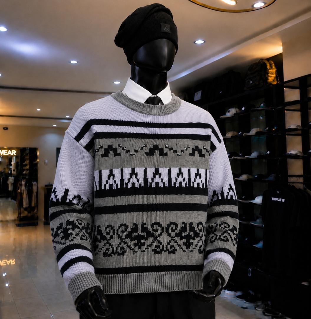 Mannequin wearing gray black and white patterned striped knit sweatshirt.