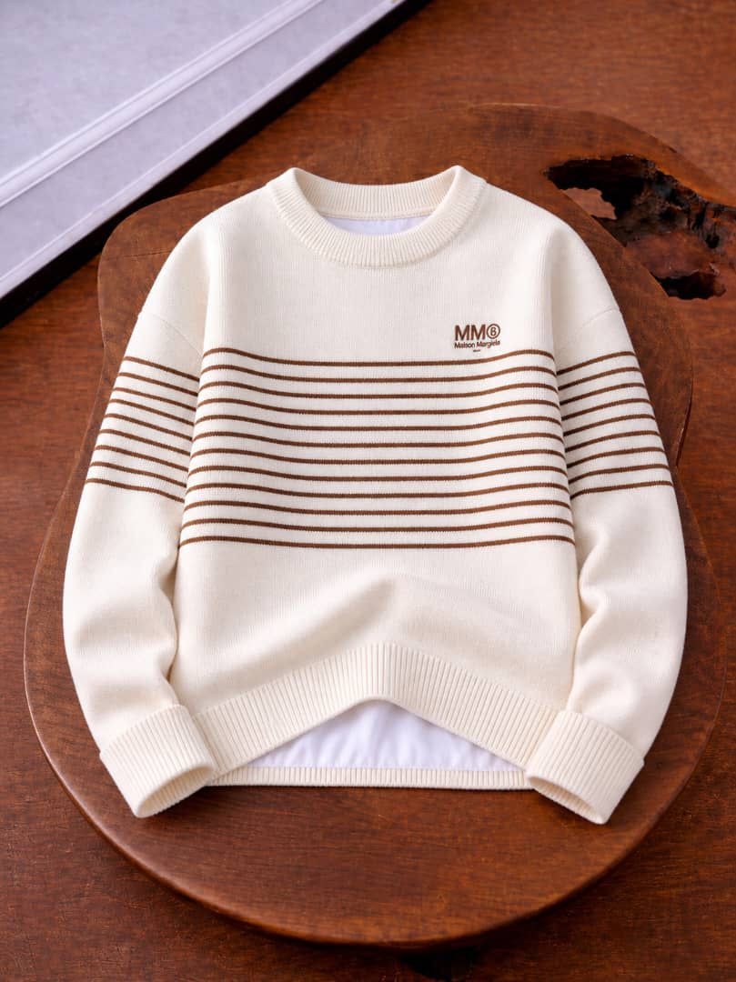 Flat lay of cream knit sweatshirt with brown stripes and MM logo.