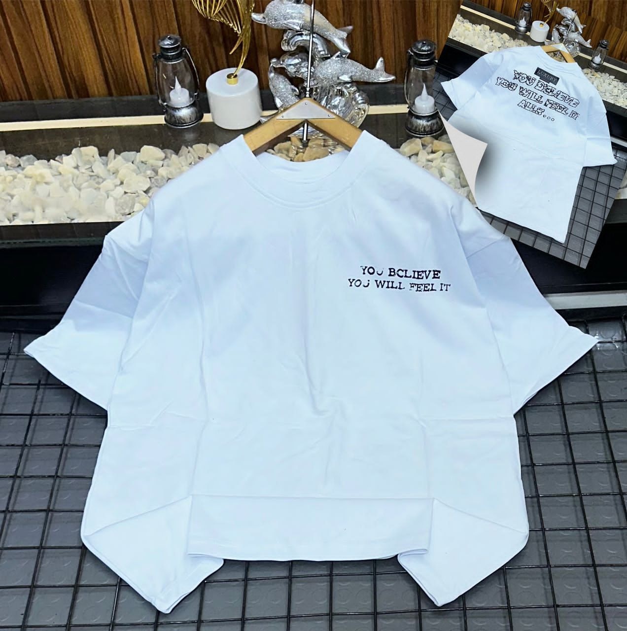 White oversized t-shirt with YOU BELIEVE YOU WILL FEEL IT text print.