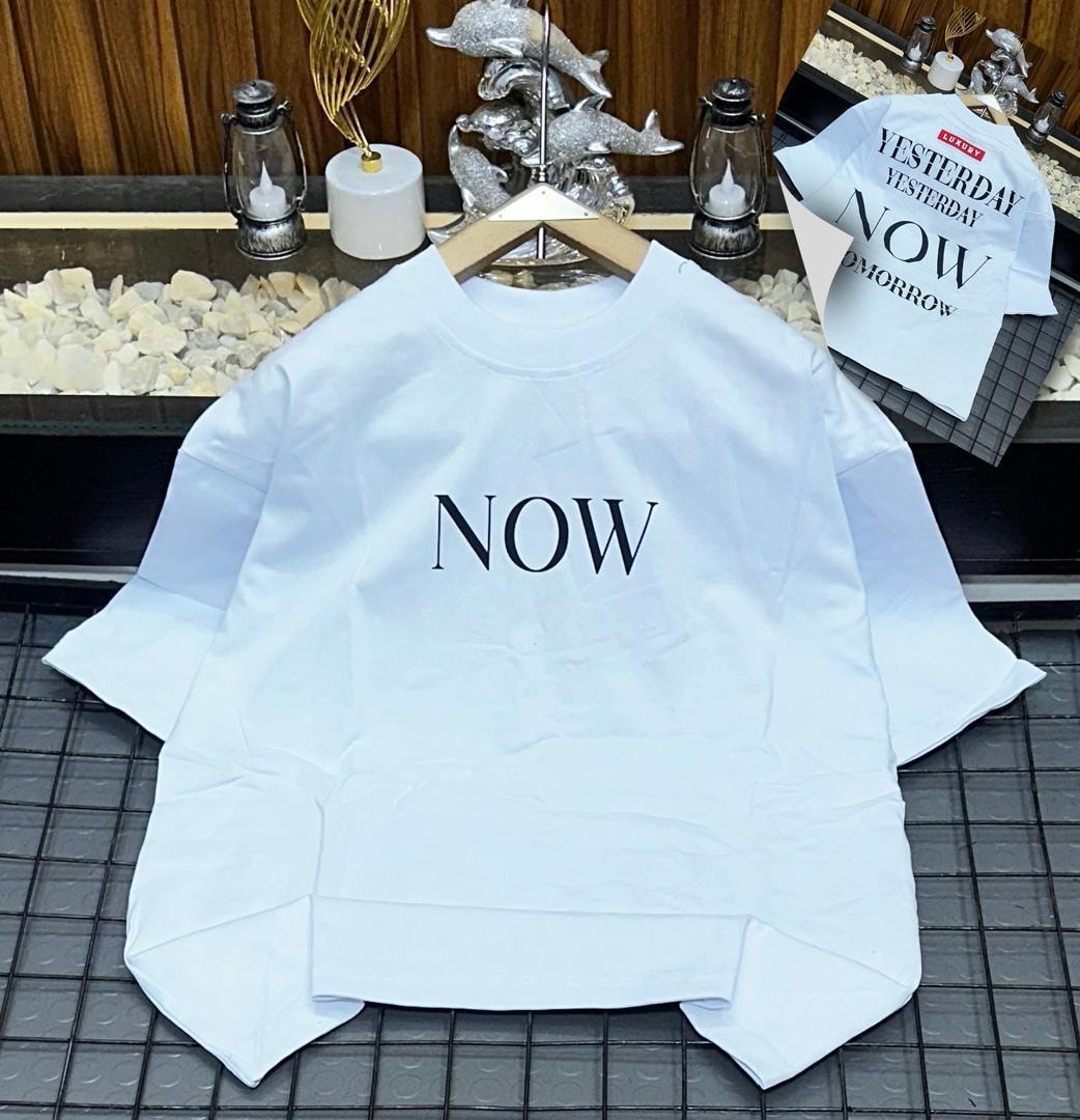 White oversized t-shirt with large NOW text on front and back text inset.