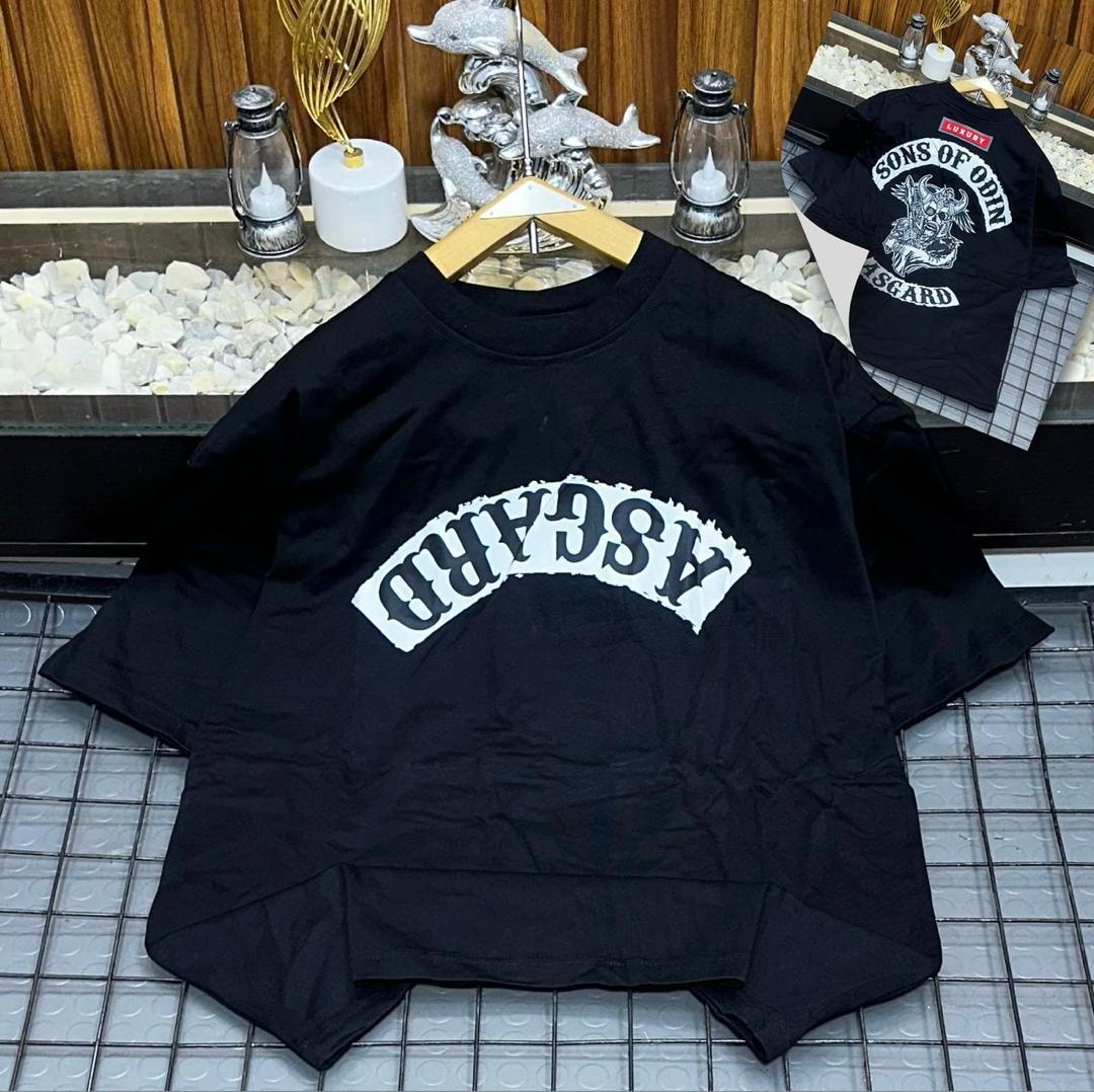 Black oversized t-shirt with ASGARD arched graphic on front displayed on tiled surface.