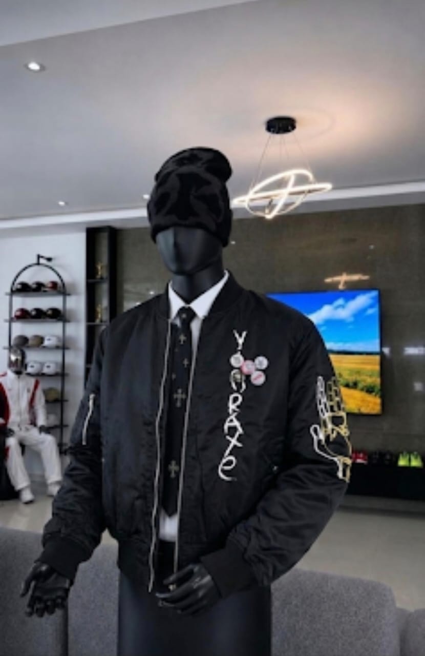 Black unisex bomber jacket with YORAXE chest embroidery and praying hands sleeve graphic on mannequin.