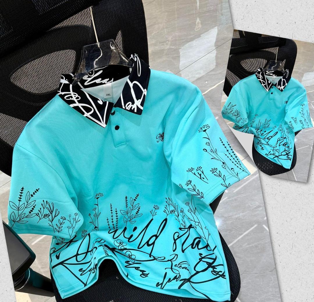 Turquoise printed polo shirt with black floral script designs and patterned collar.