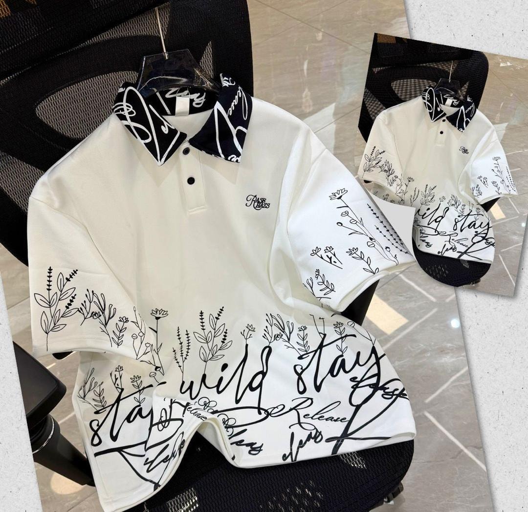 White printed polo shirt with black floral script designs and patterned collar.