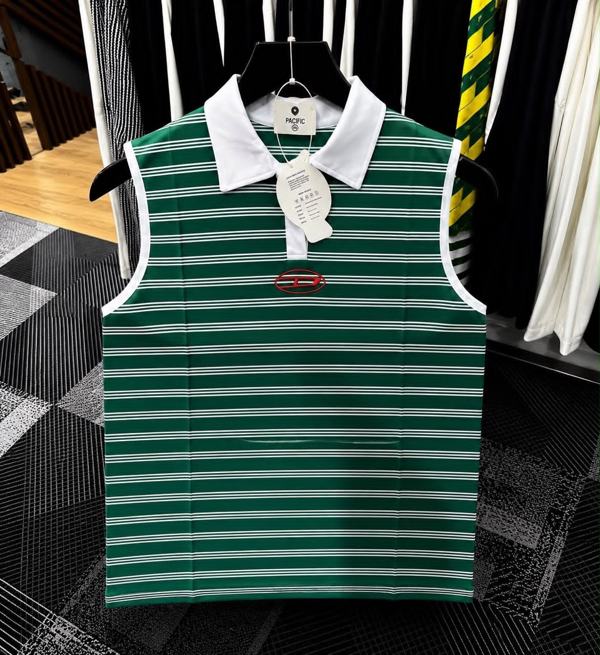 Green striped sleeveless polo top with white collar and red embroidered logo.