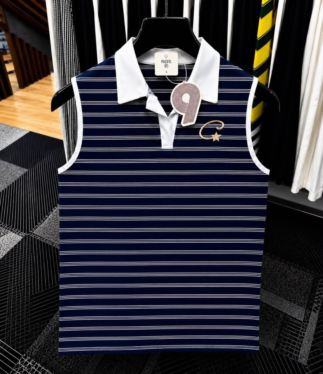 Navy striped sleeveless polo top with white collar and gold embroidered logo.