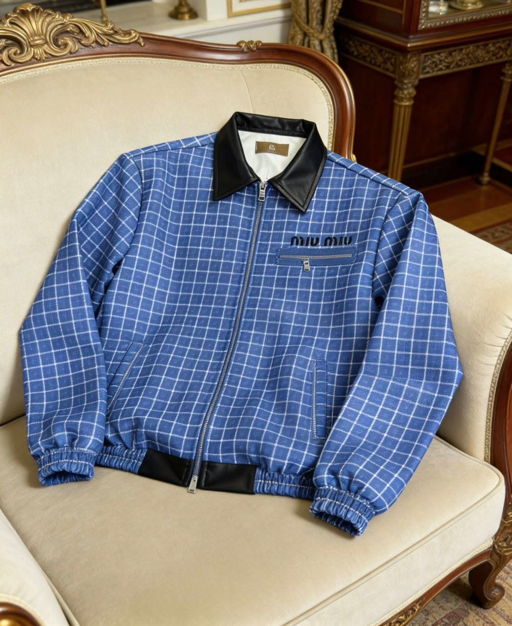 Blue checkered miu miu jacket displayed on a vintage chair.