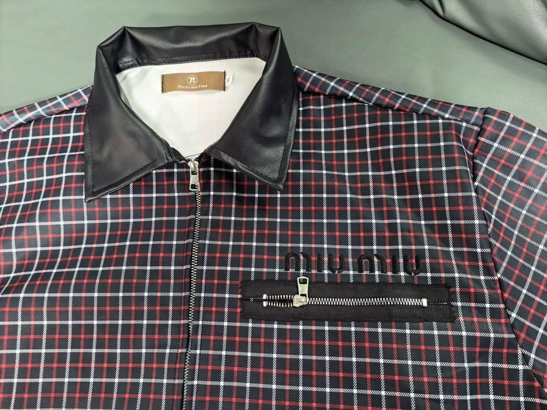 Close-up of red grid jacket showing black leather collar, inner tag, and miu miu logo.
