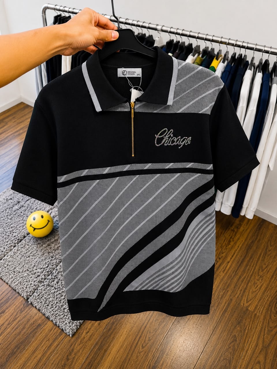 Black Chicago polo shirt with gray stripes on hanger.