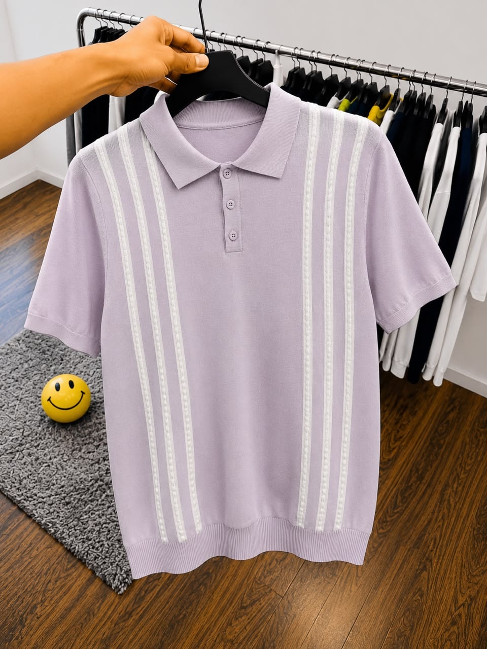 Light purple polo shirt with white vertical stripes on hanger.