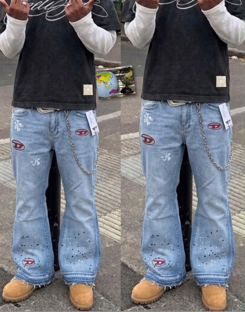 Model wearing light blue baggy jeans with red logos, paint splatters, chain and raw hem.