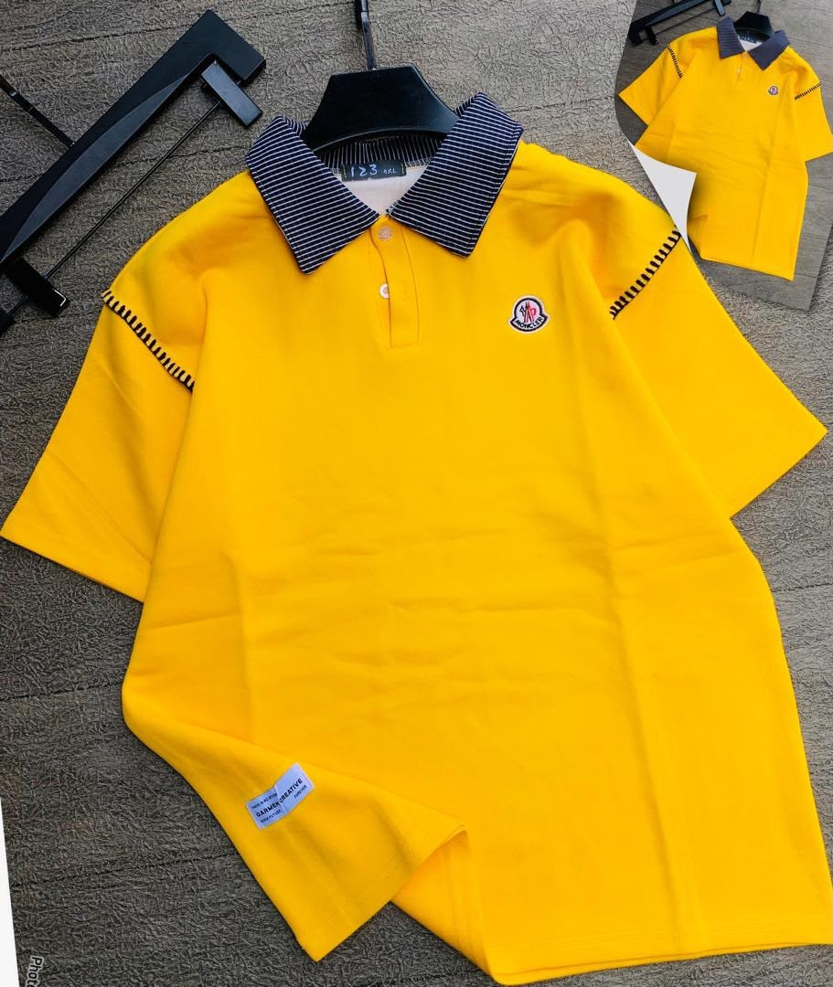Bright yellow polo shirt with striped collar laid flat on textured surface, displaying logo and details.