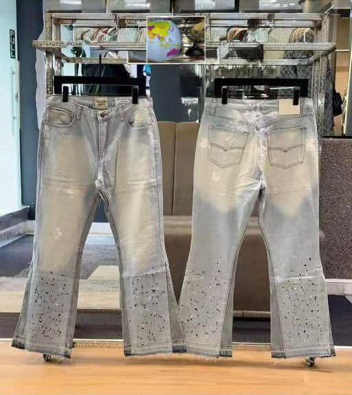 Front and back views of light gray flared jeans with black splatter on lower legs.