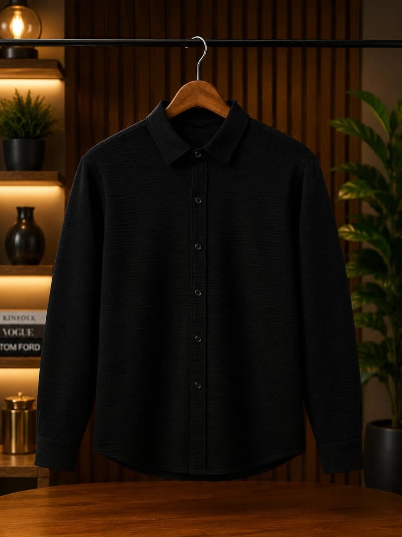 Black textured long sleeve button-down shirt hanging on wooden hanger.