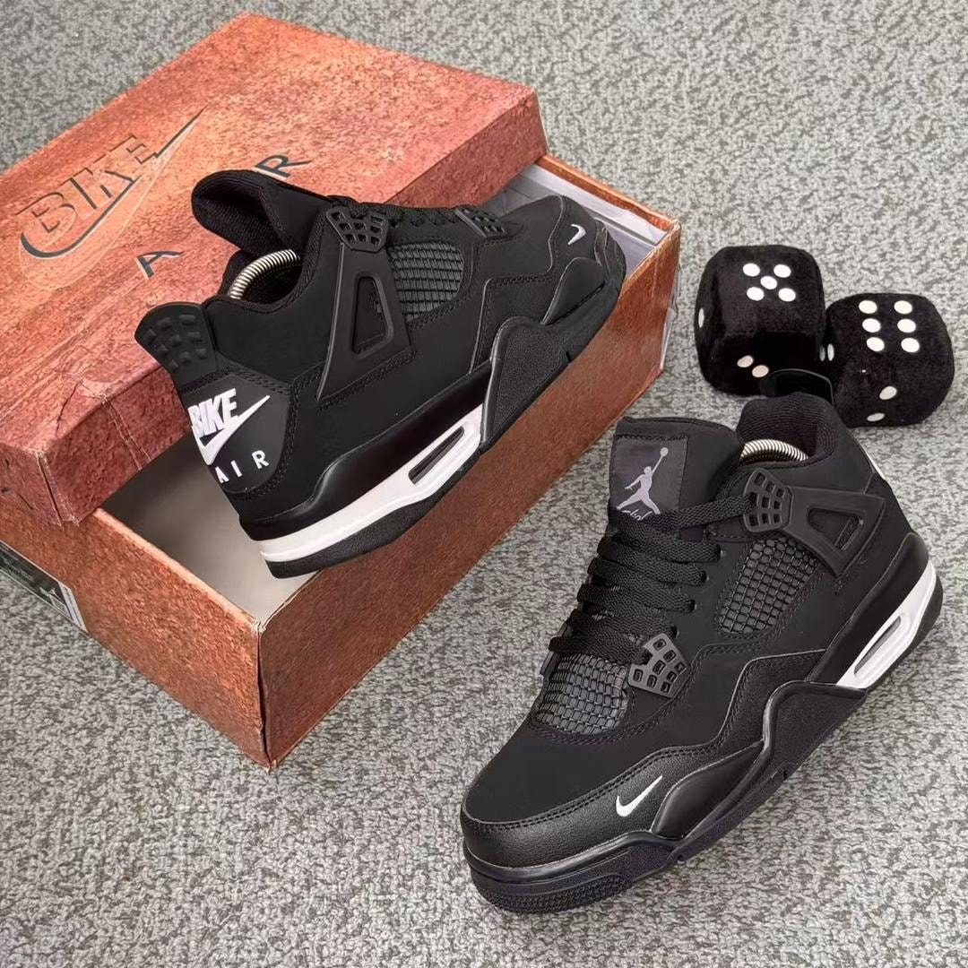 Black Nike Air Jordan 4 sneaker shown with box and dice props.