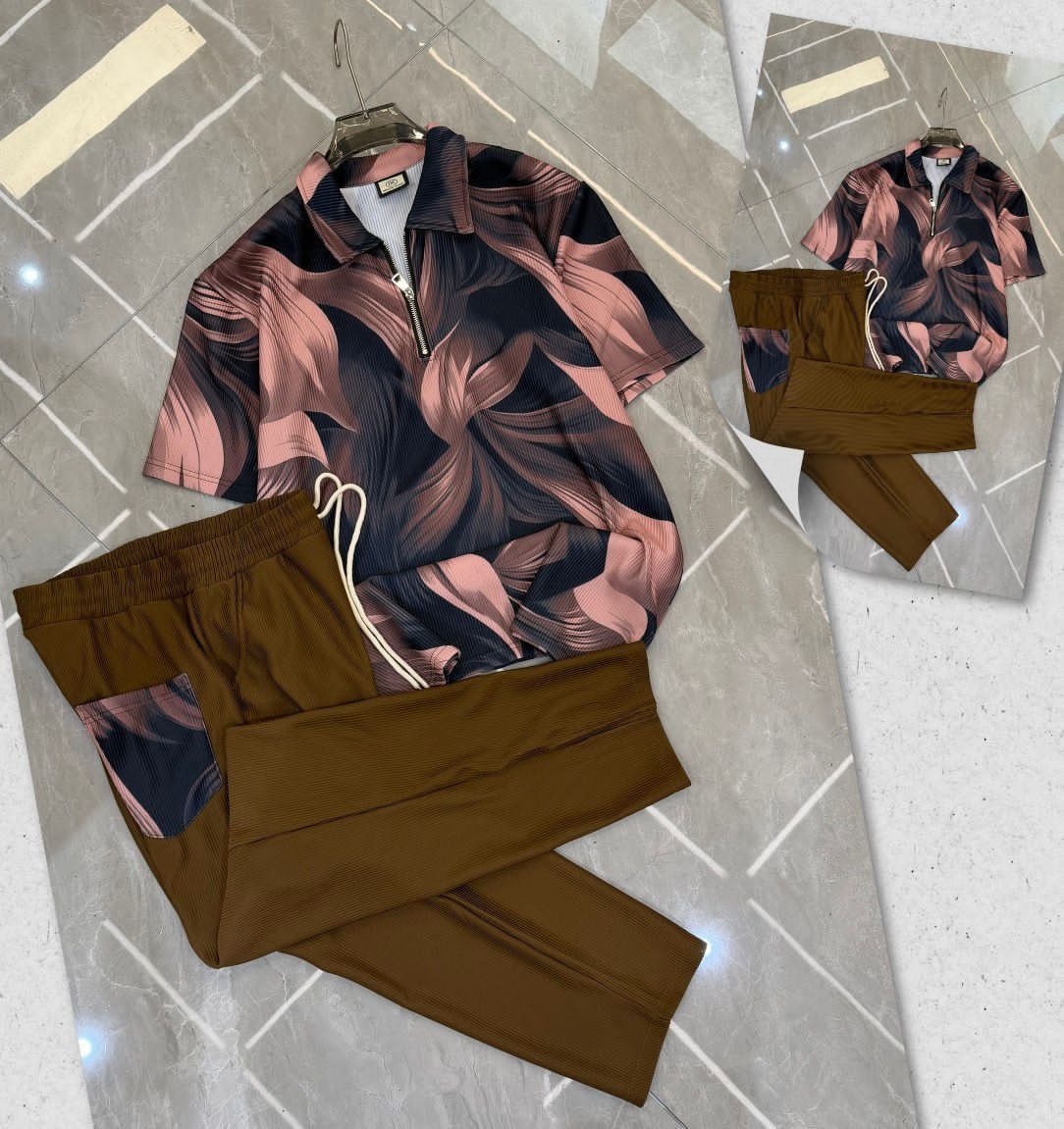 Pink and black leaf print zip polo shirt with matching brown trousers on tiled floor.