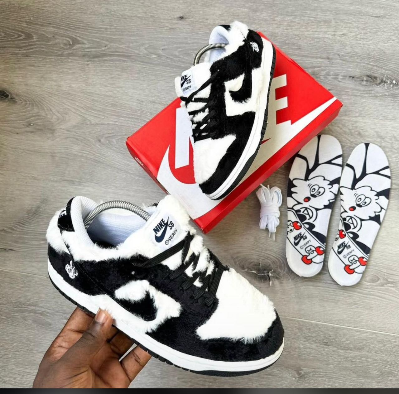 Nike SB Dunk Low in black and white furry upper with red box, insoles and extra laces.
