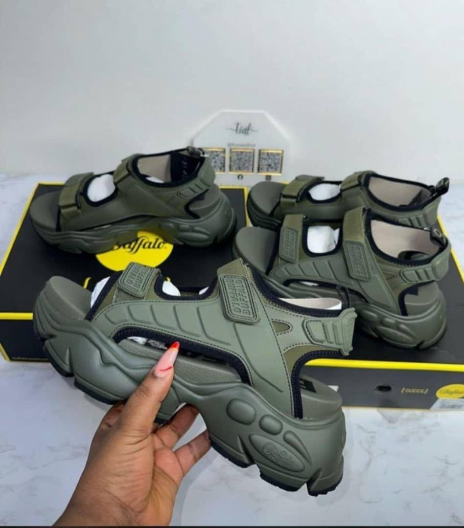 Olive green Buffalo sandals held and displayed with box.