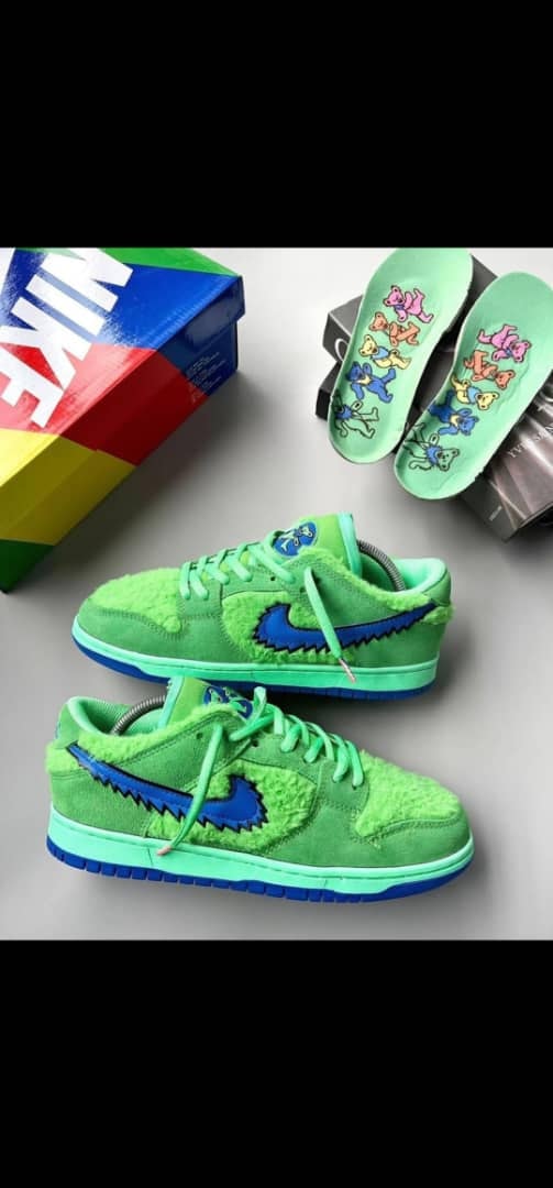 Green Nike SB Dunk Low with bear graphics, insoles and colorful box.