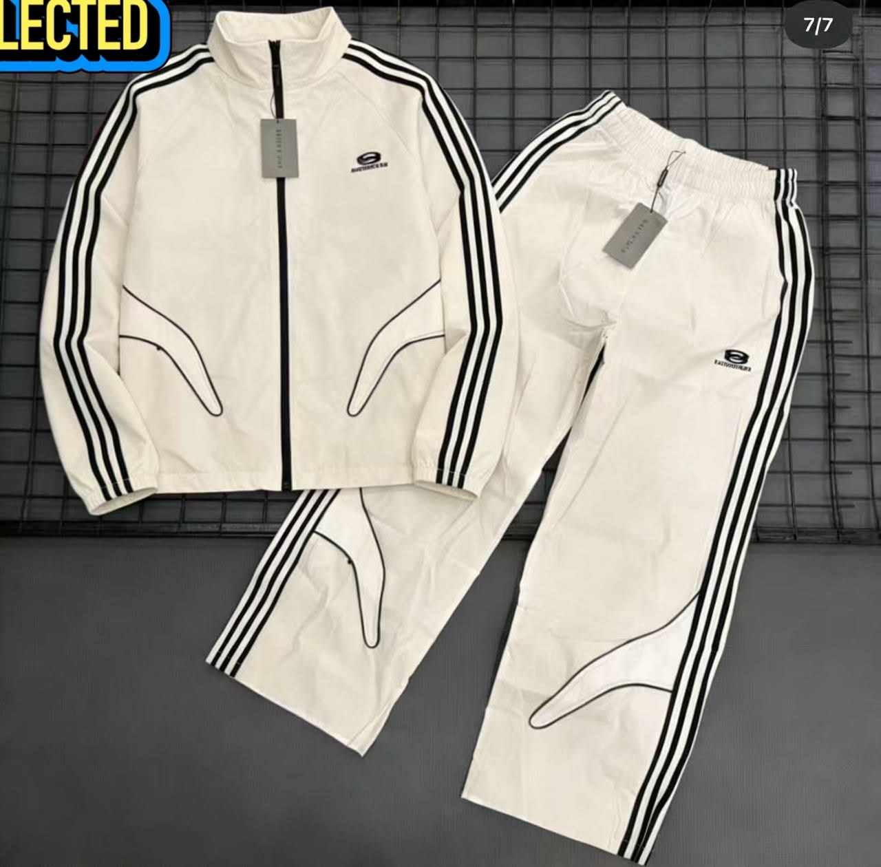 White Balenciaga tracksuit set with black stripes displayed flat on a grid.