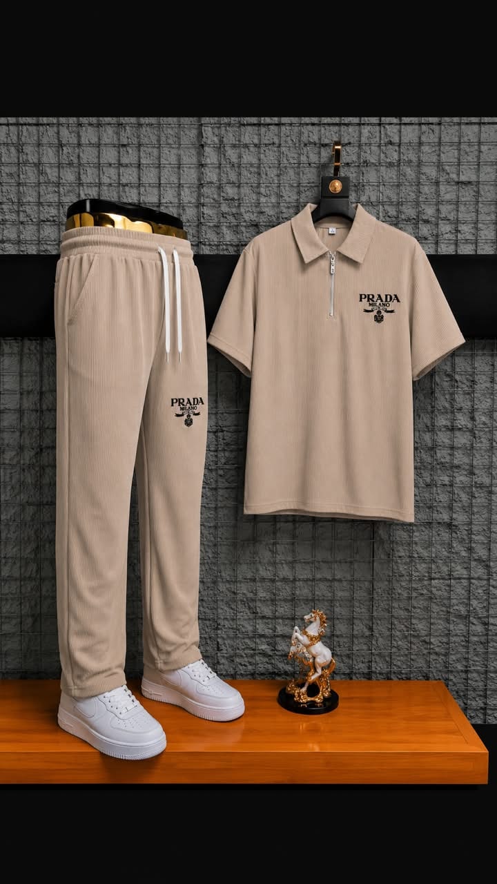 Beige ribbed polo and jogger two-piece set styled on wooden surface with accessories.