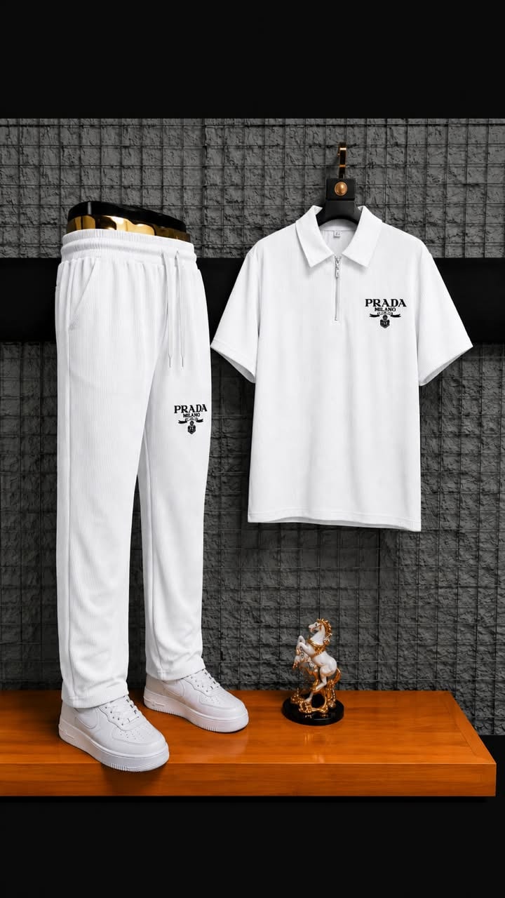White ribbed polo and jogger two-piece set styled on wooden surface with accessories.