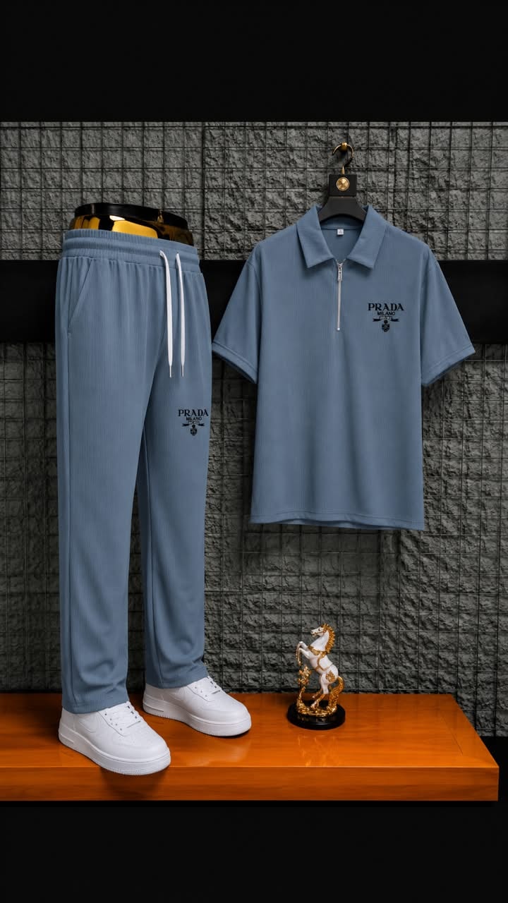Light blue ribbed polo and jogger two-piece set styled on wooden surface with accessories.