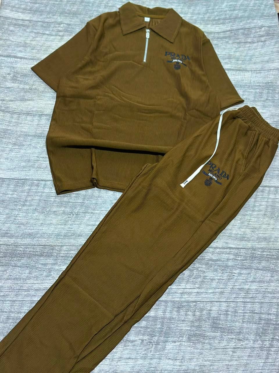 Brown ribbed polo shirt and jogger pants two-piece set laid flat on wood floor.