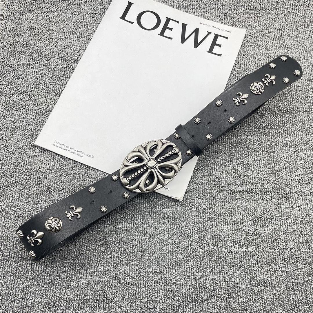 Black belt with silver fleur de lis and large ornate buckle on magazine.