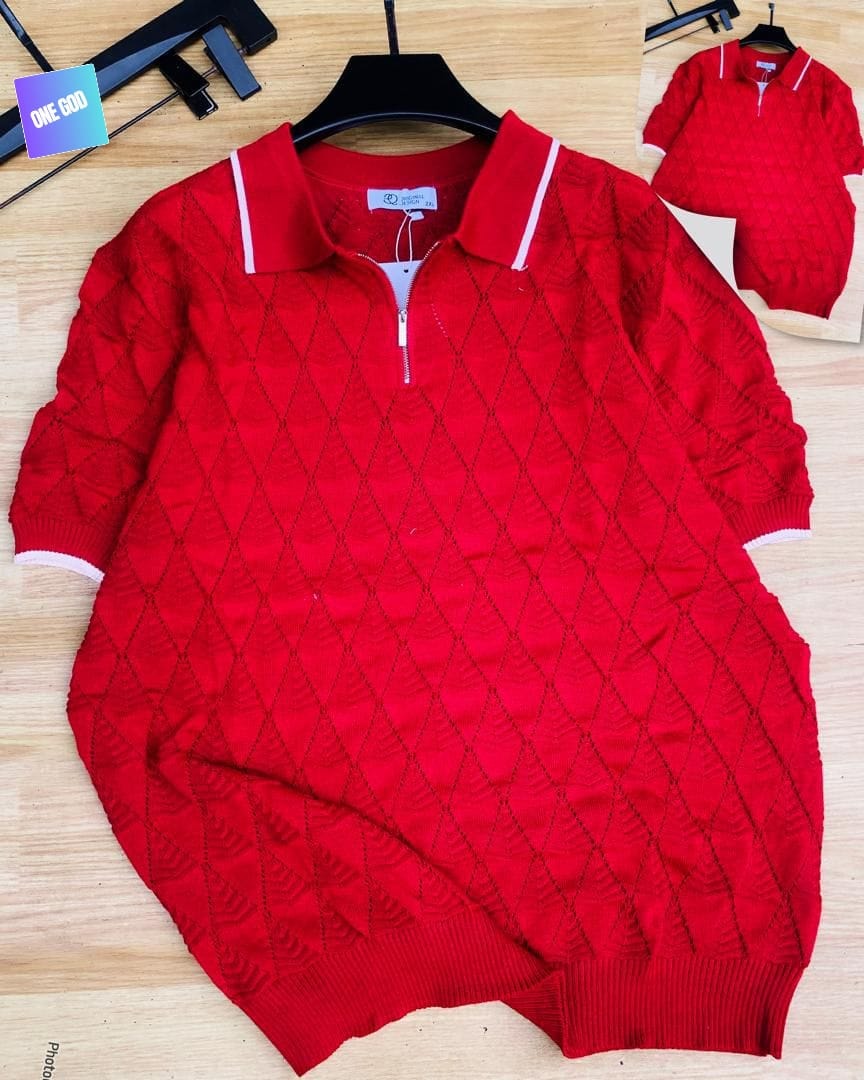 Red diamond knit quarter-zip polo with white trim on wooden background.