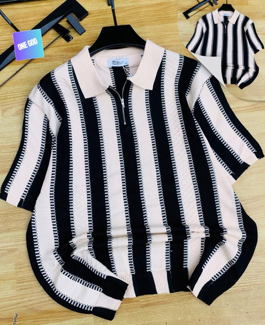 Black and cream striped knit quarter-zip polo on wooden surface.