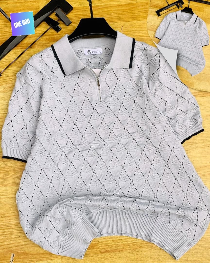 Light gray diamond knit quarter-zip polo with black trim on wooden background.