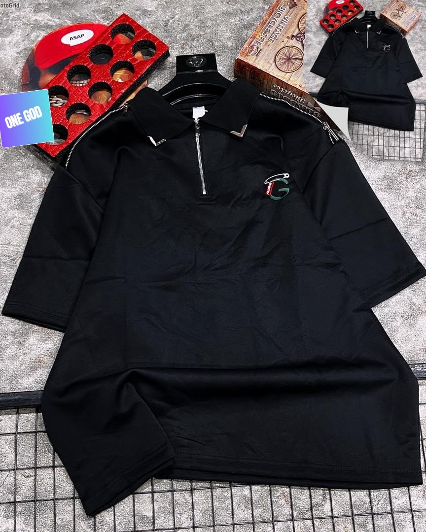Black polo shirt with quarter zip and G logo on chest.