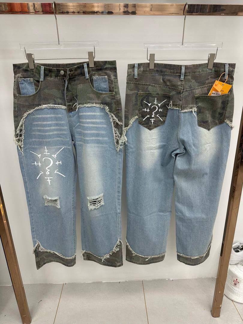 Hanging camo and blue distressed baggy jeans showing front back rips and symbolic prints.
